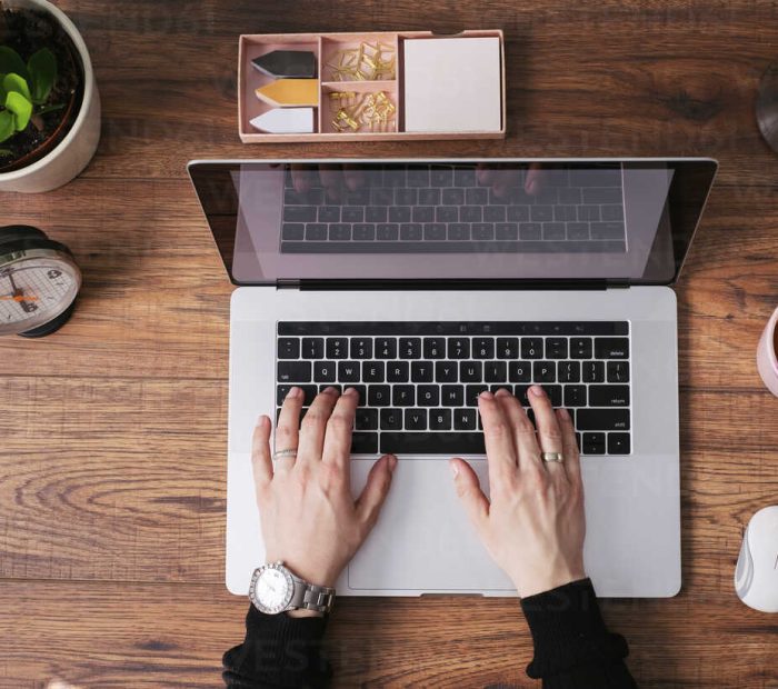 womans-hands-working-on-laptop-at-home-office-top-view-MOMF00639